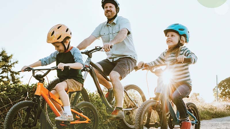 Father and children riding bicycles