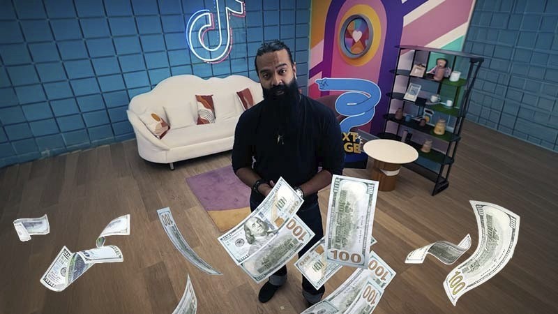 Man standing in a studio surrounded by floating dollar bills